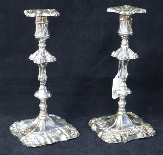 A pair of George III embossed silver candlesticks by James Stamp and John Baker, 10in.